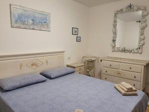 a bedroom with two beds and a dresser and a mirror at Casa Martina in Olbia