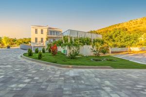 a house with a garden in front of it at Villa SALVIA - new, modern villa near Split in Dugopolje
