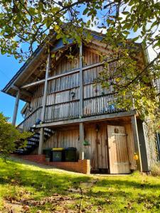 - un grand bâtiment en bois avec un grand balcon dans l'établissement Klein Kattult, à Windeck