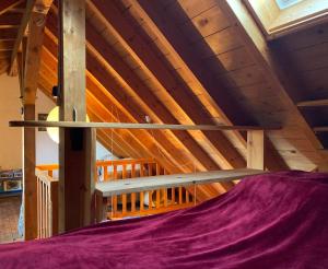 a loft bed in a room with wooden ceilings at Klein Kattult in Windeck
