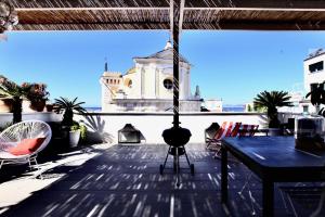 een balkon met een tafel en stoelen en een gebouw bij Maison Gioffredi in Ischia