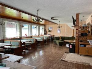 ein Restaurant mit Tischen und Stühlen in einem Zimmer mit Fenstern in der Unterkunft Ferienhaus Dankl in Hollersbach im Pinzgau