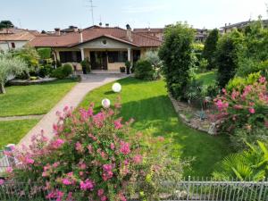 a house with a garden with pink flowers at Casa Margherita in Mozzecane