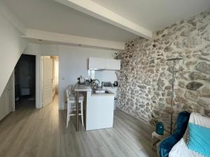 a kitchen with a stone wall and a counter top at Appartement La Tourraque côté mer in Antibes