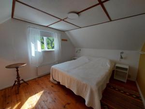 1 dormitorio con cama blanca y ventana en Stuga i Ekestad, en Kristianstad