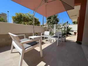 a patio with a table and chairs and an umbrella at Sun Holiday in Avola