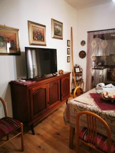 een woonkamer met een flatscreen-tv op een entertainmentcentrum bij Casa Mastio in Galtellì