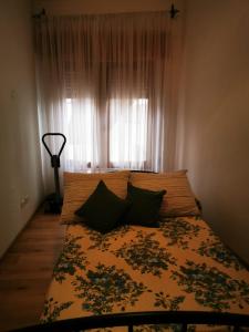 een slaapkamer met een bed en een raam met gordijnen bij Casa Mastio in Galtellì