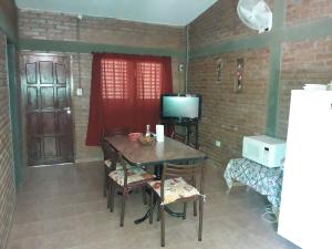 a dining room with a table and a television at Cabañas Don Pocho in Villa Cura Brochero