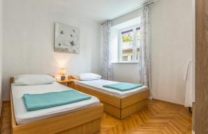 2 Betten in einem Zimmer mit Fenster in der Unterkunft TORETA Apartment - city center, beachfront in Omiš