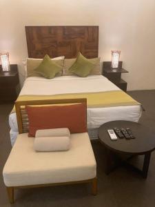 a bedroom with a large bed with a chair and a table at Kandaya Resort in Daanbantayan
