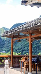 a wooden pergola with a table and a mountain at Riverside Retreat Hotel in Yangshuo