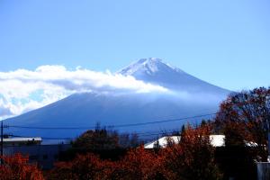 a snow covered mountain in the distance with clouds at Maruyaso in Fujikawaguchiko