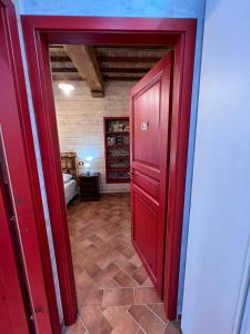 uma porta vermelha que leva a uma sala com um quarto em Agriturismo Santo Regolo - relax toscano ✺✺✺ em Torretta