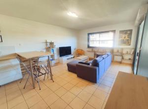 a living room with a couch and a table at Le Dory - Appartement Centre Ville avec Terrasse, Parking & Wifi in Montpellier