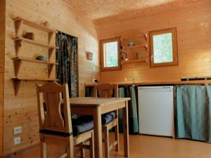 eine Küche mit einem Tisch und Stühlen in einer Hütte in der Unterkunft Gite et cabane écologiques 1000 Pailles in Labastide-de-Virac