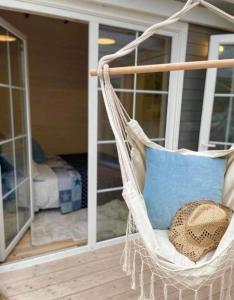 a wicker chair with a blue pillow on a porch at Happy In Dębki in Dębki