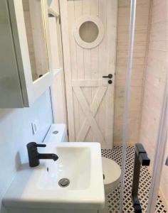 łazienka z umywalką, toaletą i drzwiami w obiekcie Happy In Dębki w Dębkach