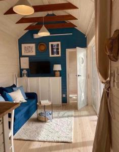 ein Wohnzimmer mit blauen Wänden und einem blauen Sofa in der Unterkunft Happy In Dębki in Dębki