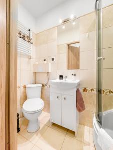 a bathroom with a toilet and a sink and a shower at COCO Apartments Gdańsk Centrum Górka in Gdańsk