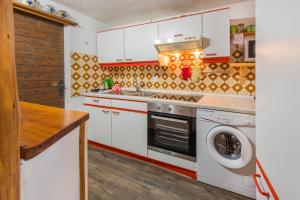 a kitchen with a washing machine and a washer at Casa Tavernela in Vicosoprano