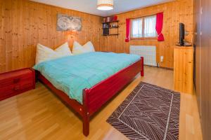 a bedroom with a bed in a room with wooden walls at Casa Tavernela in Vicosoprano