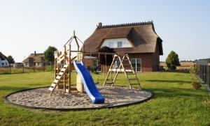 a playground in front of a house with a slide at Ferienhaus Auszeit an der Üselitzer Wiek in Mellnitz