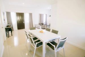 uma sala de jantar com uma mesa branca e cadeiras em Kandaya Resort em Daanbantayan