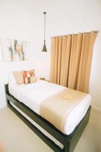 1 dormitorio con cama grande y cortina en Kandaya Resort, en Daanbantayan