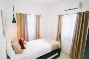 a small bedroom with a bed and a window at Kandaya Resort in Daanbantayan