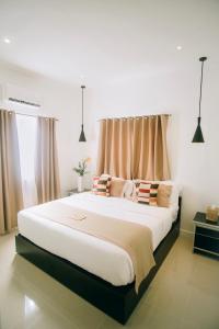 Daanbantayanにあるカンダヤ リゾートのカーテン付きの客室で、白い大型ベッド1台が備わります。