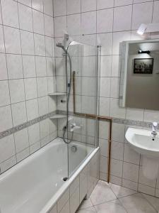 a bathroom with a shower and a tub and a sink at Apartment Mokotów Wernyhory in Warsaw