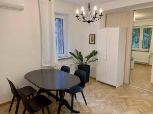 uma sala de jantar com uma mesa preta e cadeiras em Apartment Mokotów Wernyhory em Varsóvia