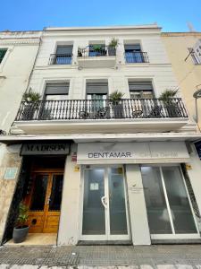 a white building with a balcony on top of it at Madison Rooms in Sitges