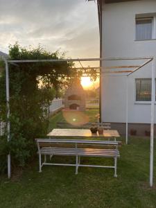 a bench in a yard with the sunset in the background at Apartman Aerodrom Sarajevo in Sarajevo