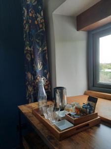 a wooden table with glasses and a bottle on it at Longstone Bed & Breakfast in Challacombe