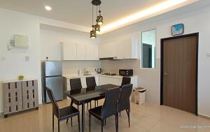 a kitchen with a table and chairs in a room at Austin @ Novo 8 in Malacca