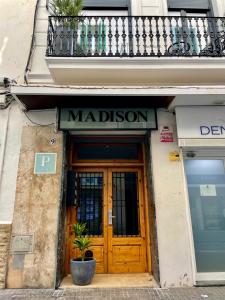 a building with a wooden door and a sign above it at Madison Rooms in Sitges