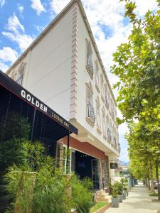 een gebouw met een bord met gouden huis hotel bij Hotel Golden in Elbasan