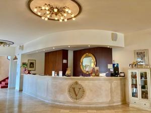 vestíbulo del hotel con mostrador de recepción y espejo en Hotel Vedute, en Fucecchio