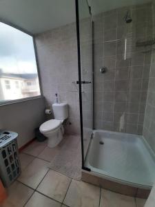 een badkamer met een douche, een toilet en een bad bij Siesta in Hermanus