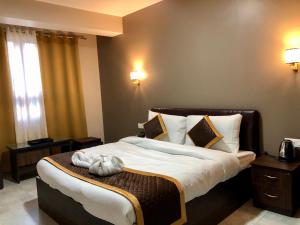 sypialnia z dużym łóżkiem z białą pościelą w obiekcie ALL SEASONS HOTEL w mieście Gangtok