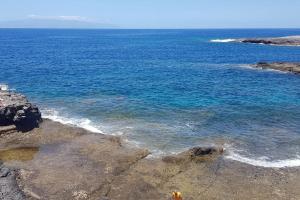 a view of the ocean from a rocky beach at Apto increíble, acogedor, luminoso de ambiente muy relajante con excelentes vistas y servicios/ Amazing apt with sunset lovely views in Adeje