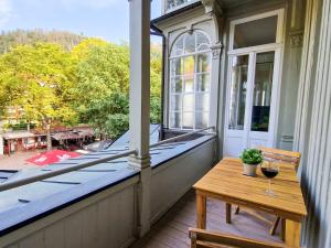 een balkon met een tafel en een glas wijn bij EUPHORAS - Central & Stylish Apartment - Parking in Bad Harzburg