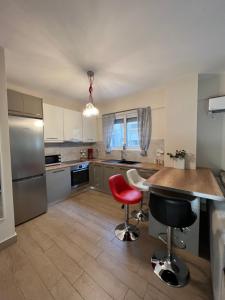 a kitchen with a table and two bar stools at Vicky’s studio in Piraeus