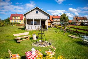 un patio con una mesa de picnic y una casa en Magia Krutyni, en Krutyń