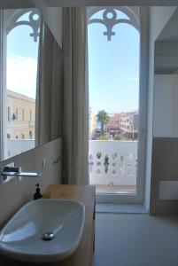 un bagno con lavandino e ampia finestra di Palazzo Del Cavaliere a Gallipoli