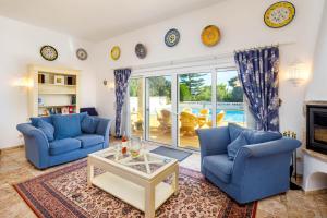 a living room with two blue chairs and a fireplace at Casa Cupula in Poço Partido