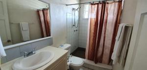 Un baño con lavabo, inodoro y ducha. en Malfranza Apartments, en Bridgetown 18 fotos más