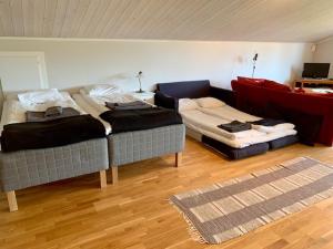 Cette chambre comprend deux lits et un canapé. dans l'établissement Kastellegården, à Kungälv